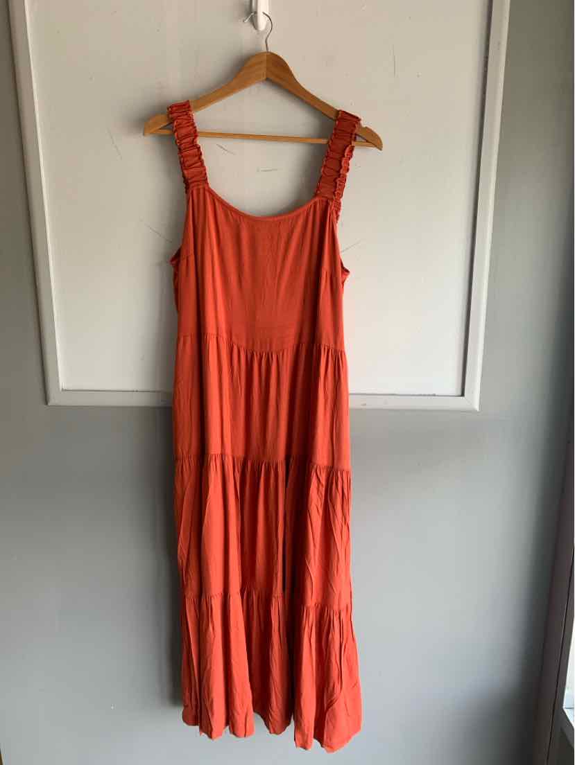 Sleeveless orange maxi dress with ruffled straps and gathered tiered skirt in lightweight fabric.