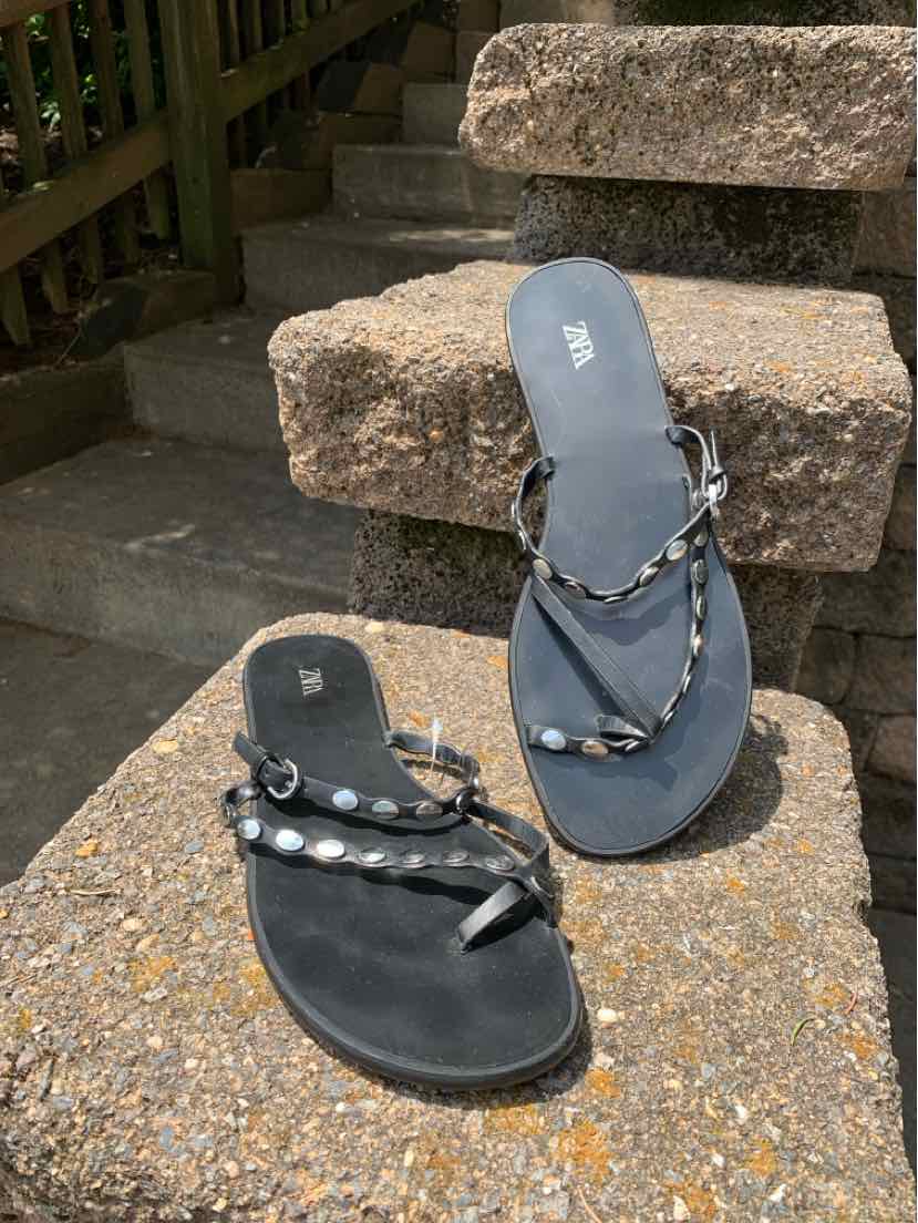 Black flat sandals with studded straps and toe loop, size 38, casual style.