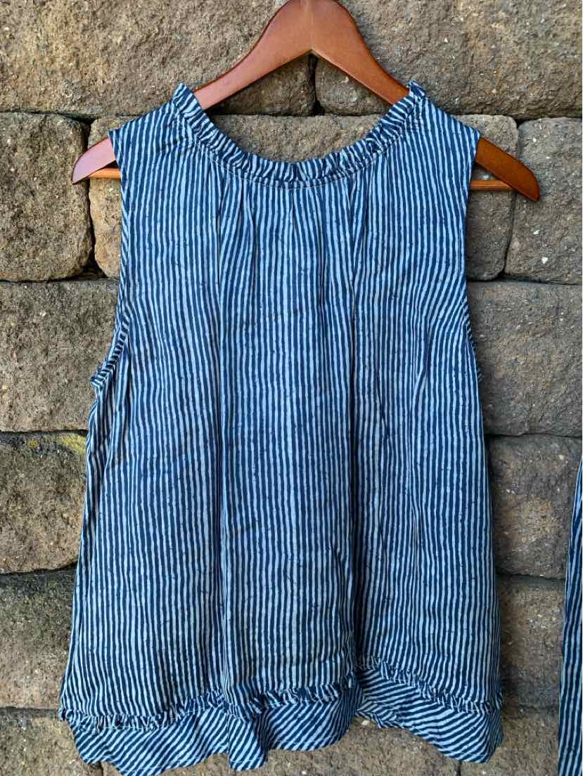 Blue and white vertical striped sleeveless blouse with a ruffled hem on a wooden hanger.