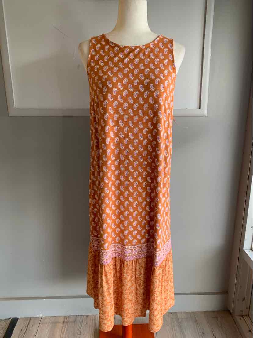 Sleeveless orange maxi dress with white geometric print and pink border at hem.