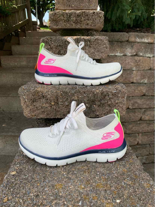 Women's beige Skechers sneakers with pink and neon green accents, white laces, and thick cushioned soles.