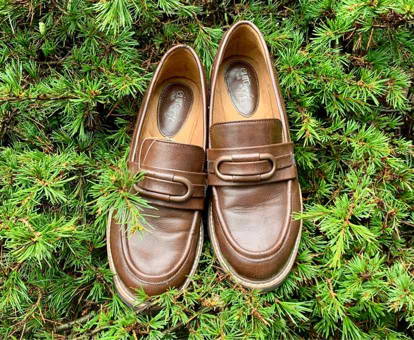 Pair of brown leather loafers with rounded toes and decorative strap detail, size 8.
