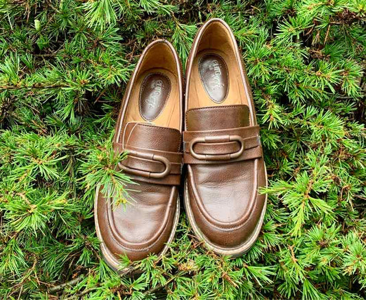 Pair of brown leather loafers with rounded toes and decorative strap detail, size 8.