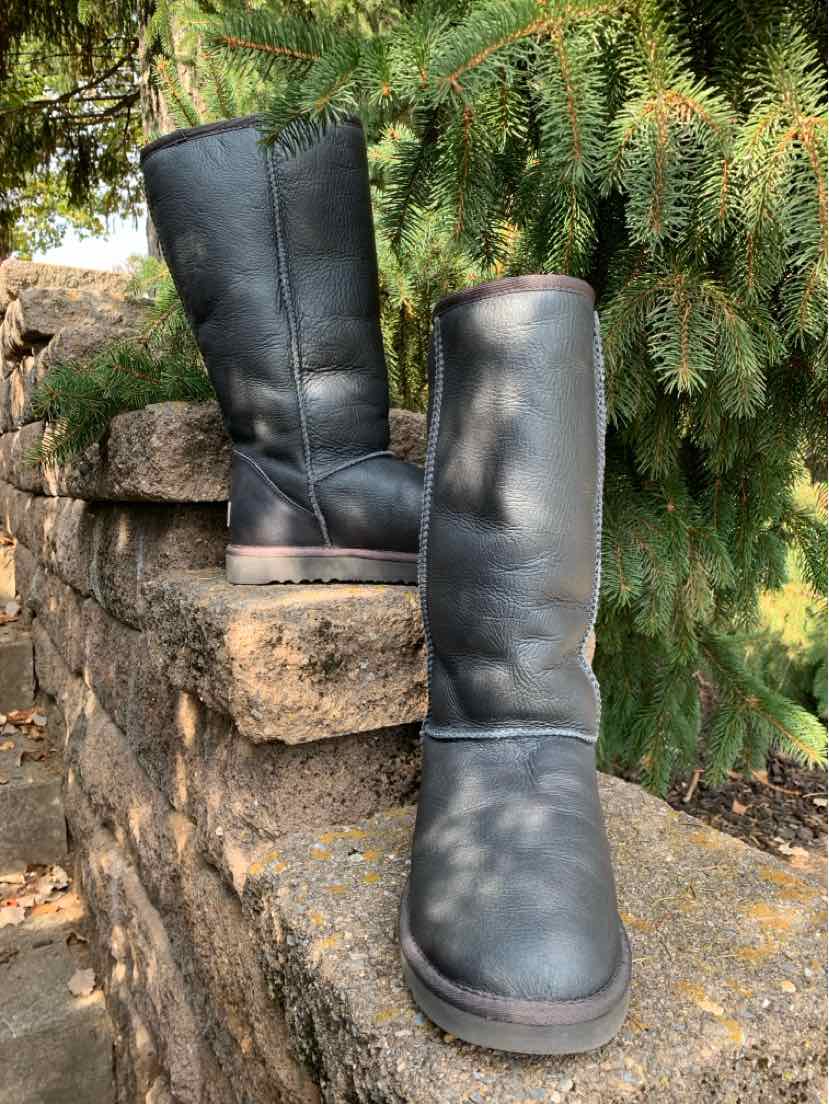Pair of charcoal gray UGG boots with tall shafts, rounded toes, and soft metallic-finish uppers.