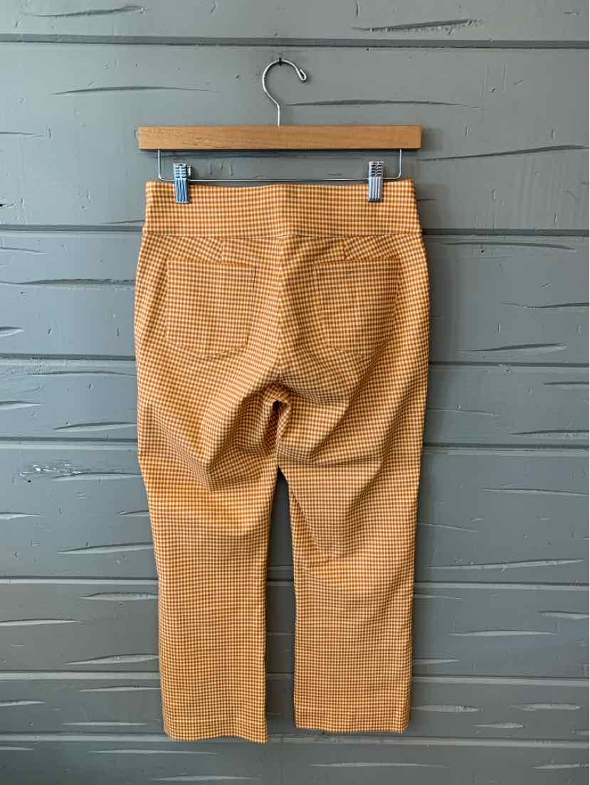 Tan textured pants in size 2 with back pockets and straight legs hanging on wooden hanger.