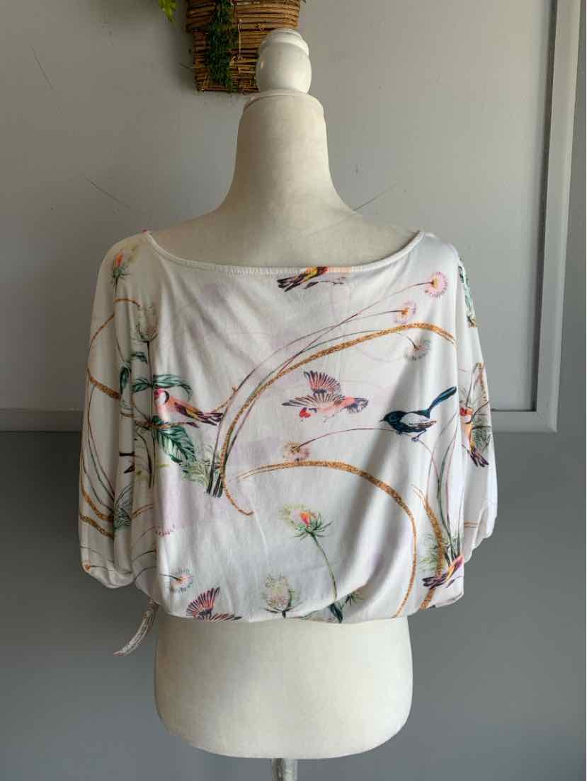 White cropped blouse with colorful floral and butterfly print, loose fit, scoop neckline, and short sleeves with adjustable.