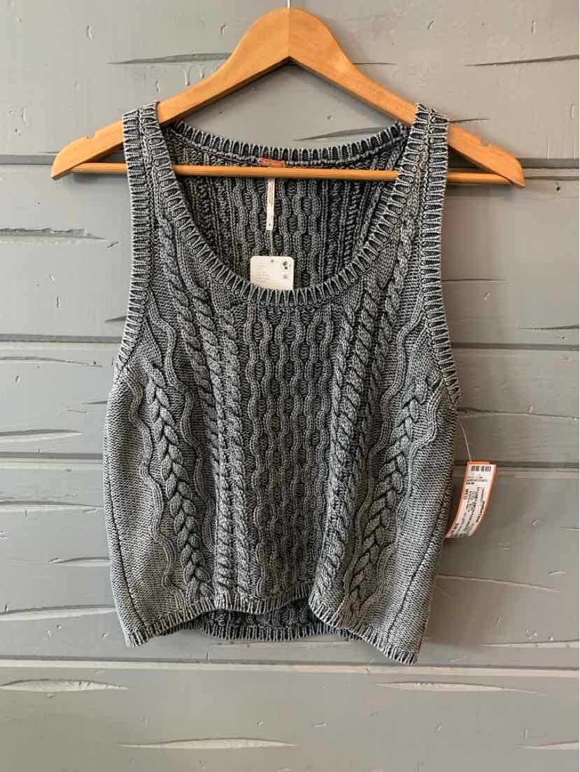 Gray knit sleeveless cropped sweater with cable patterns and ribbed edges on wooden hanger.