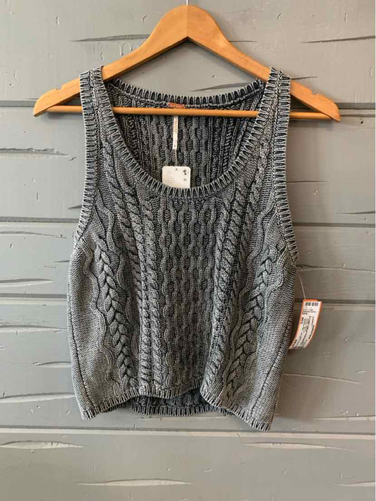 Gray knit sleeveless cropped sweater with cable patterns and ribbed edges on wooden hanger.