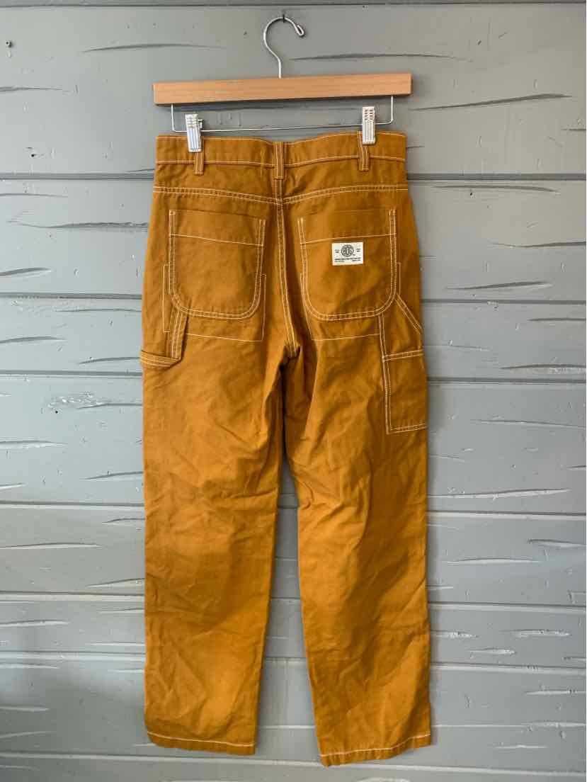 Rust-colored straight-leg pants with large back pockets and a small white patch on the right pocket.