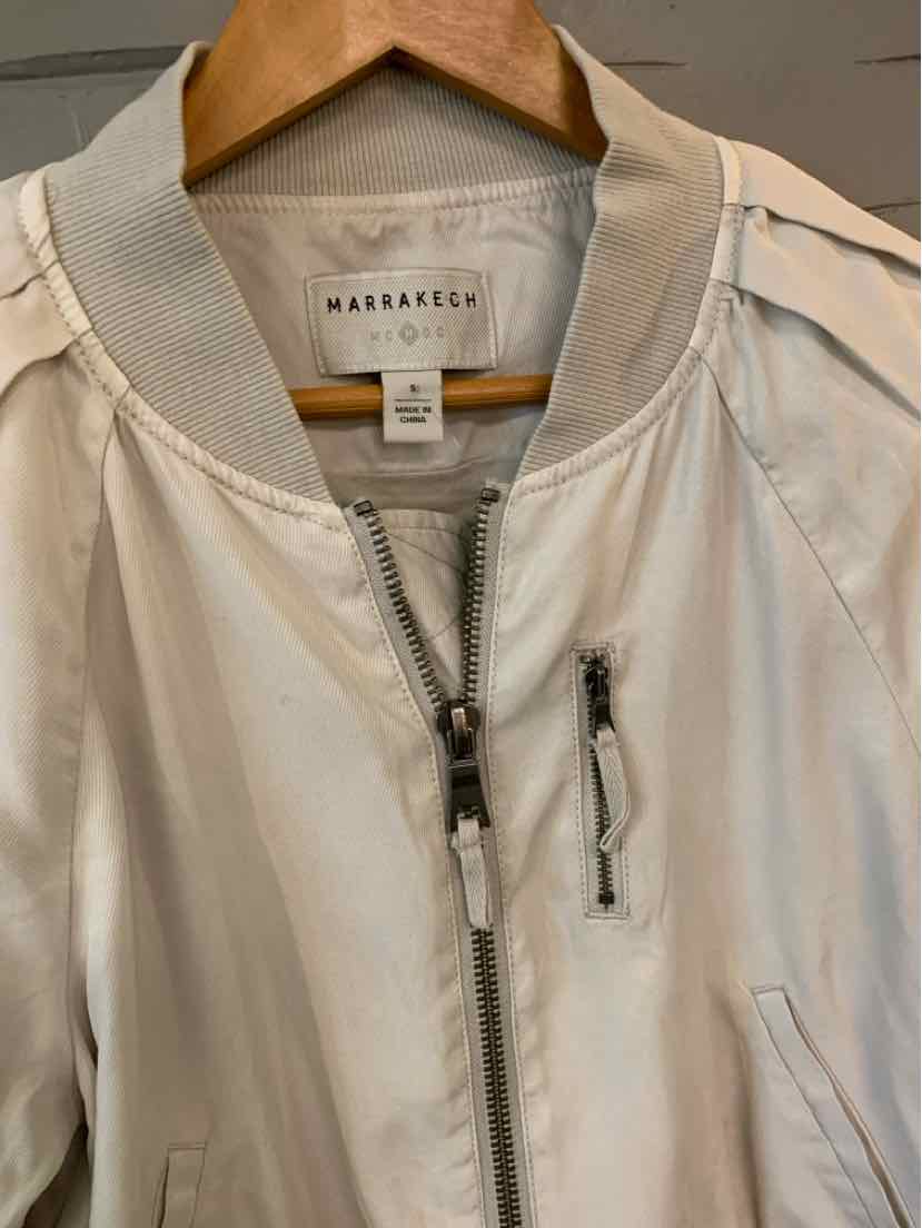 Light beige bomber jacket with ribbed collar, silver zipper, and a small chest pocket zipper detail.