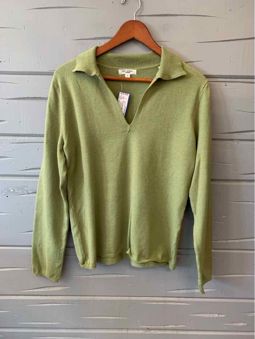 Light green long-sleeve knit sweater with a collar and V-neck hanging on wooden hanger.