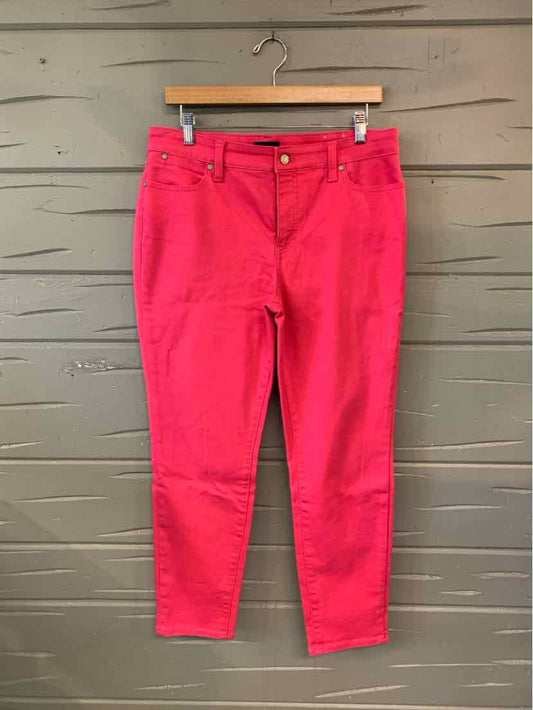 Bright pink straight-leg pants with front pockets and belt loops hanging on wooden hanger.