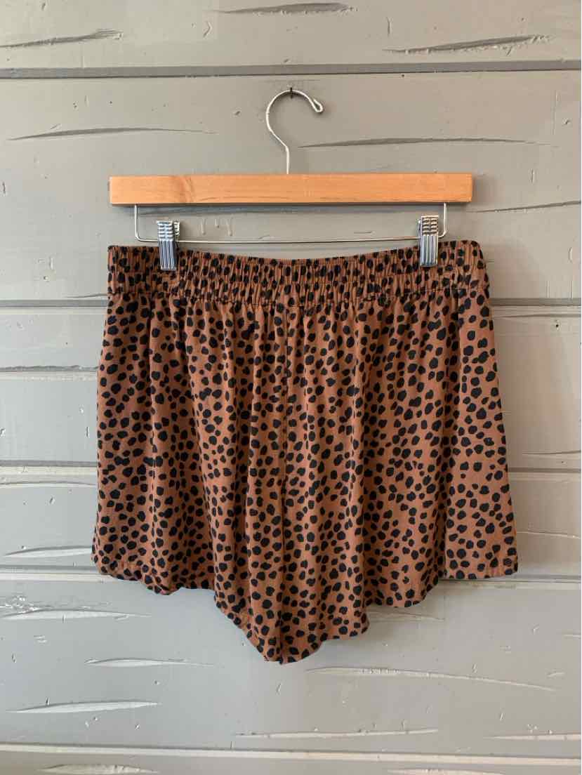 Beige shorts with black polka dots, elastic waistband, lightweight fabric, casual style.