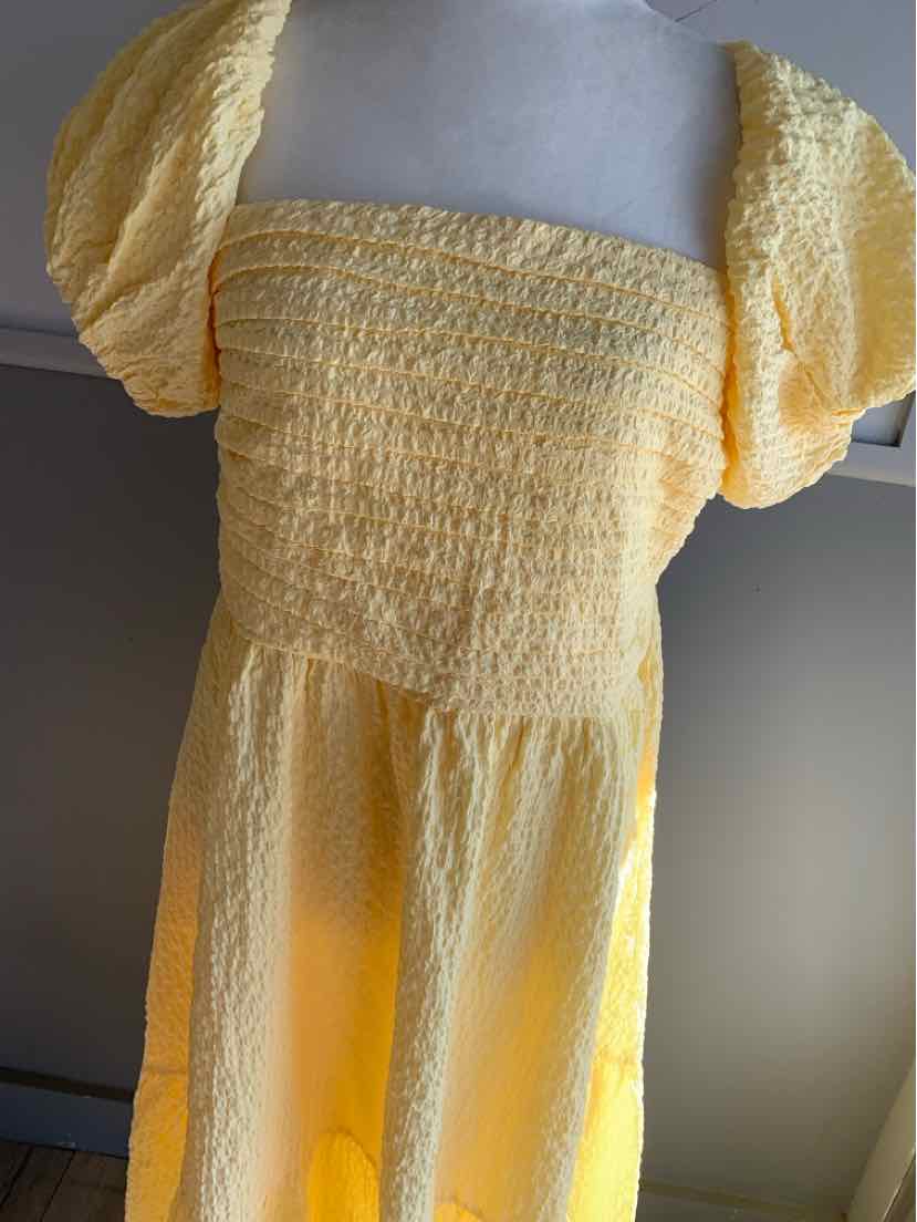 Yellow smocked bodice dress with puff sleeves in lightweight fabric.
