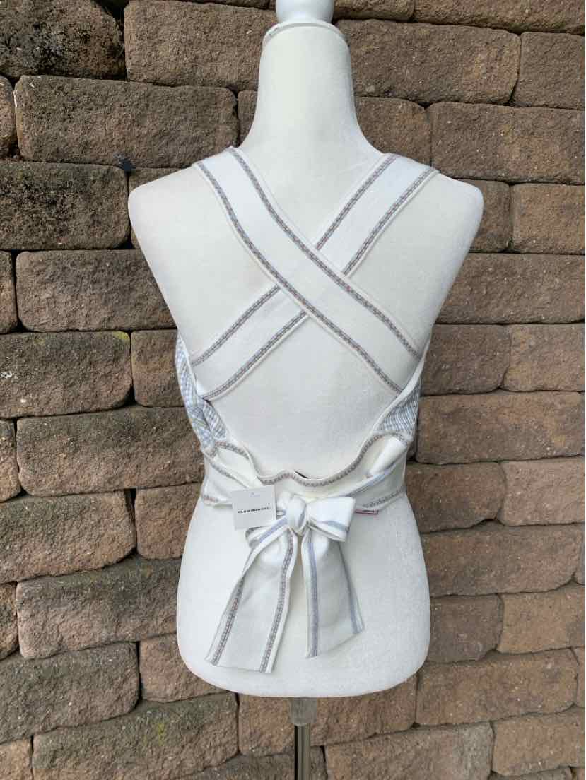 White knit sleeveless top with crisscross back straps and a tied bow at the waist.