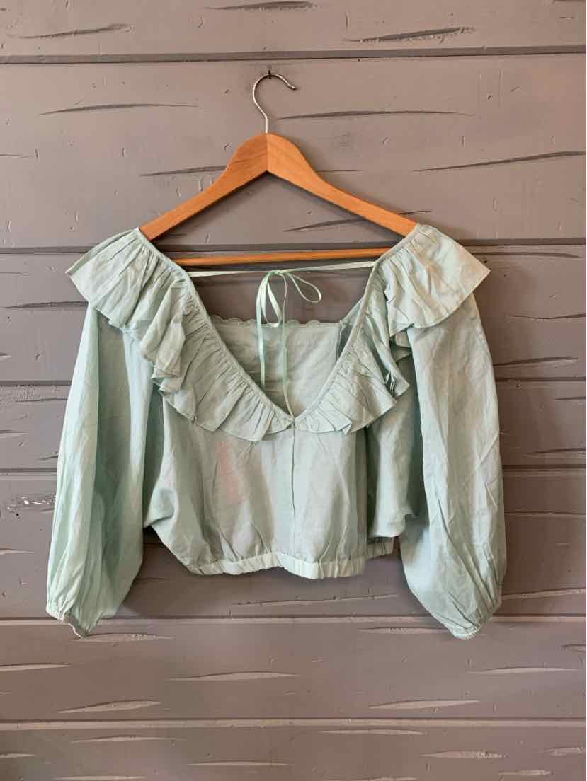 Light mint green cropped blouse with ruffled off-shoulder neckline and long puff sleeves.