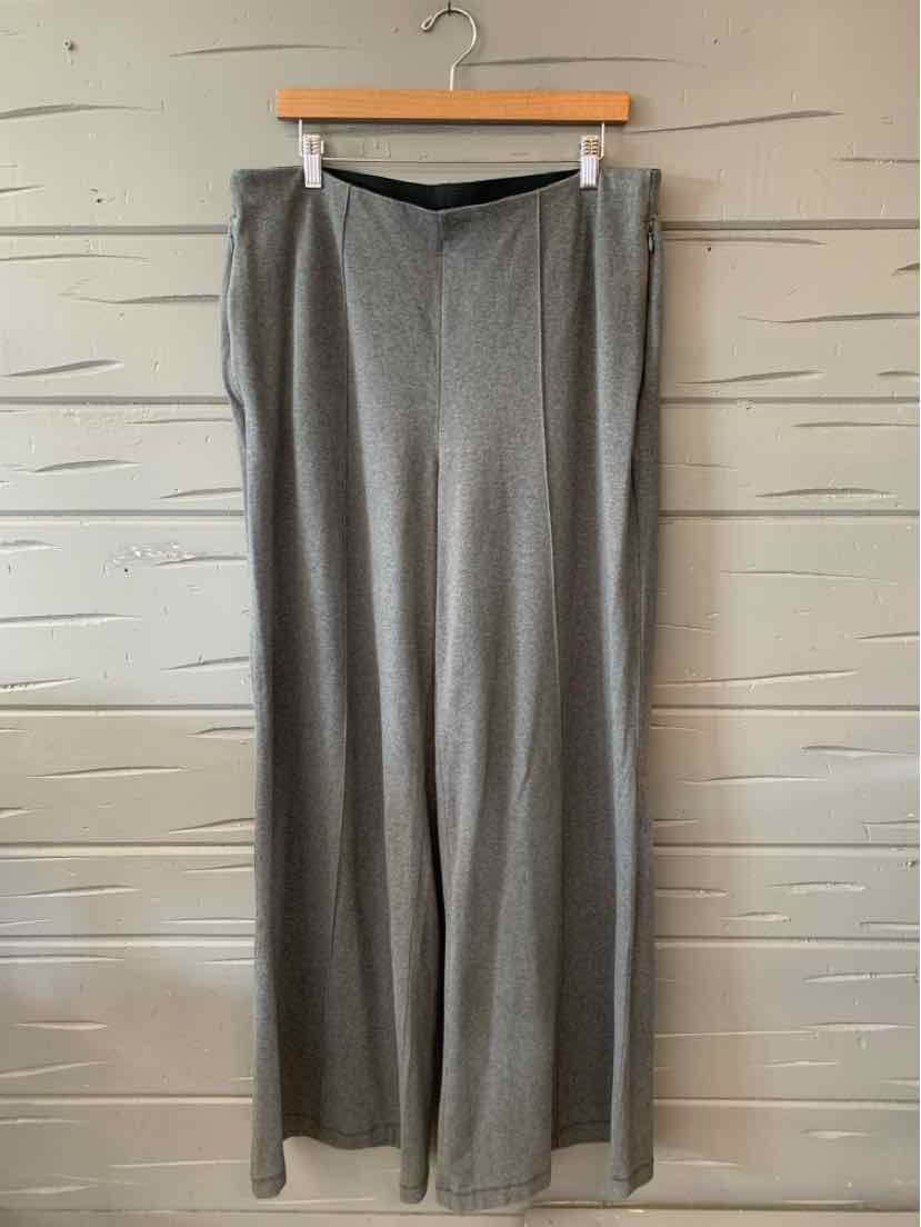 Light gray, wide-leg trousers with a smooth front and flat waistband, hanging on wooden hanger.
