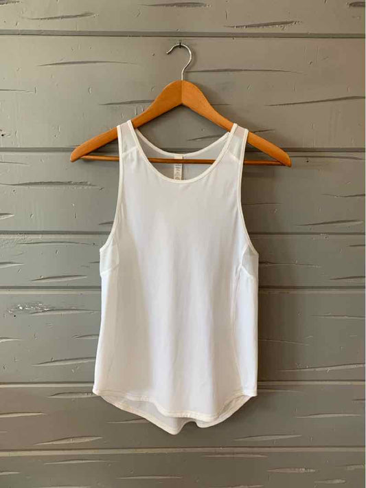 White sleeveless athletic tank top with scoop neck and curved hem on wooden hanger.
