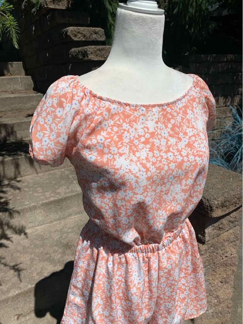 Light pink floral blouse with short puff sleeves, round neckline, and elastic waist in large size.