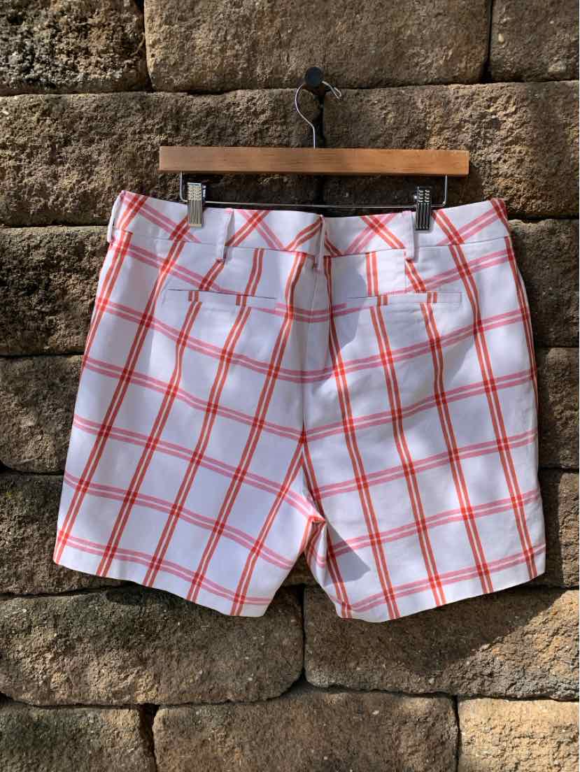 White shorts with red plaid pattern, back pockets, and size 16W label on wooden hanger.