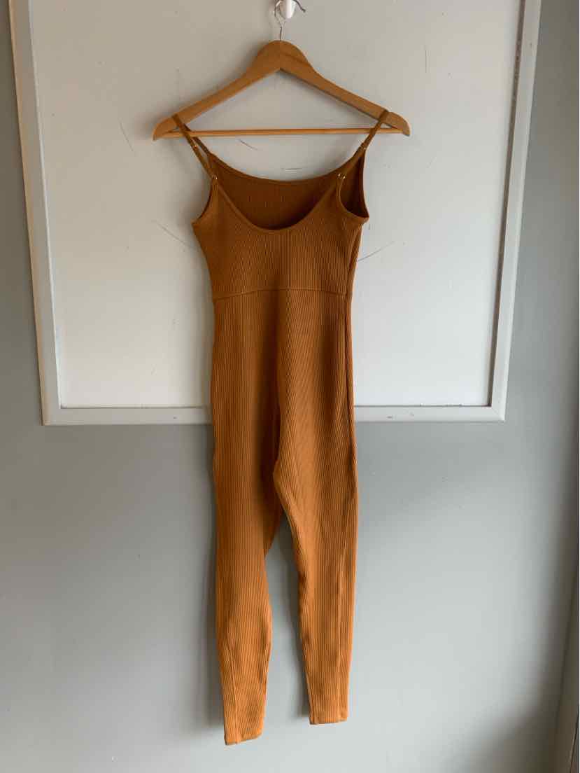 Copper-colored sleeveless ribbed knit jumpsuit with scoop neckline on wooden hanger.