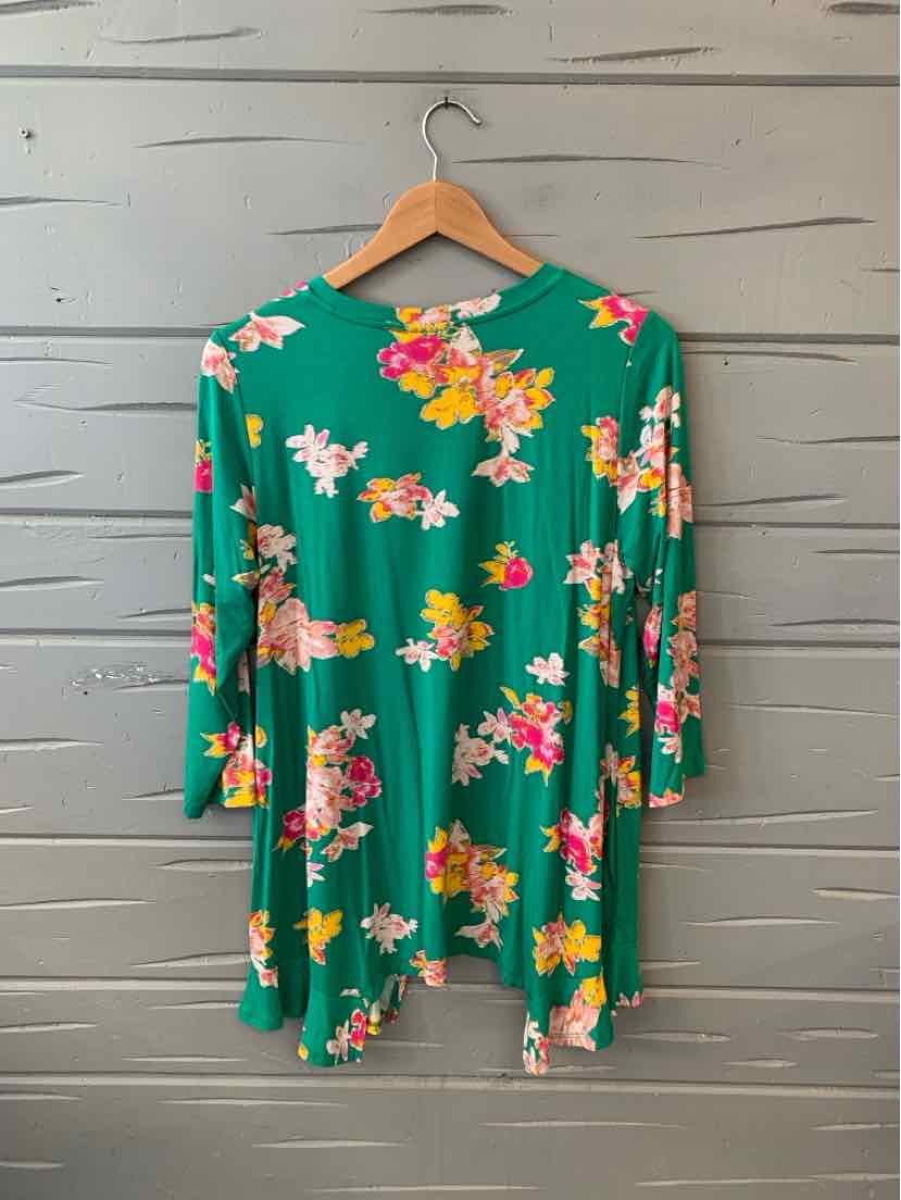 Green floral long-sleeve shirt with pink, white, and yellow flowers on wooden hanger.