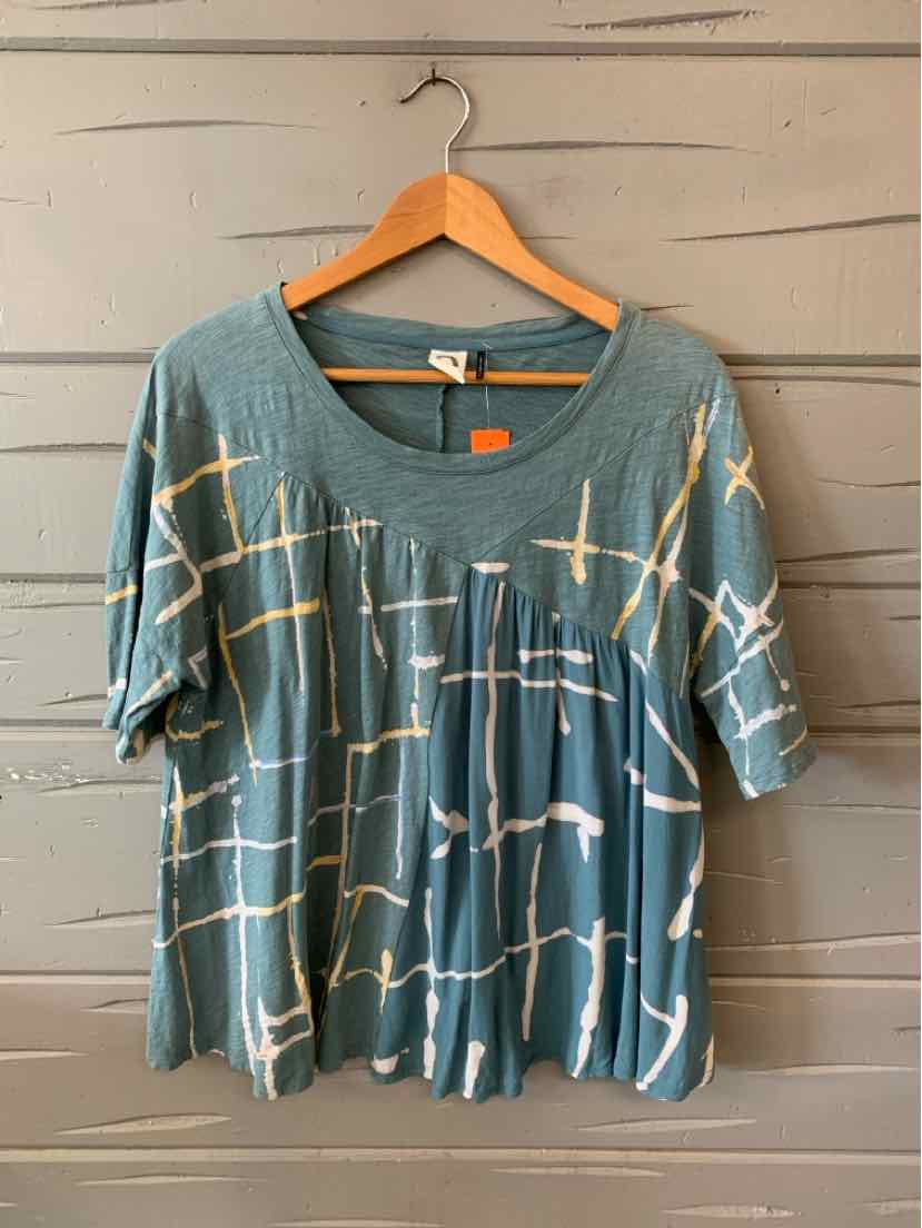 Loose-fit teal short-sleeve top with white and beige abstract grid pattern and round neckline.