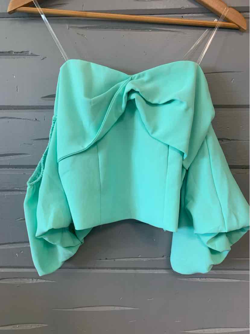 Mint green off-shoulder crop top with puffy long sleeves and front bow detail on wooden hanger.