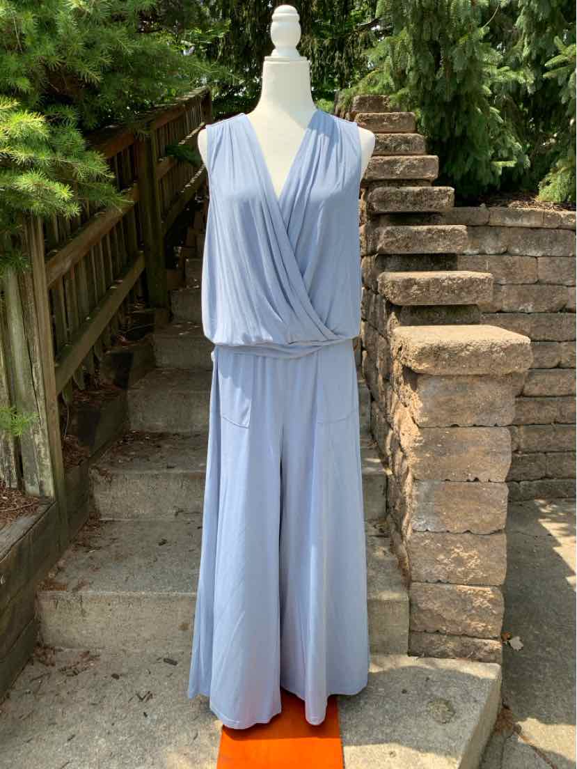 Light blue sleeveless wrap-front wide-leg jumpsuit with a cinched waist, displayed on a mannequin outdoors.
