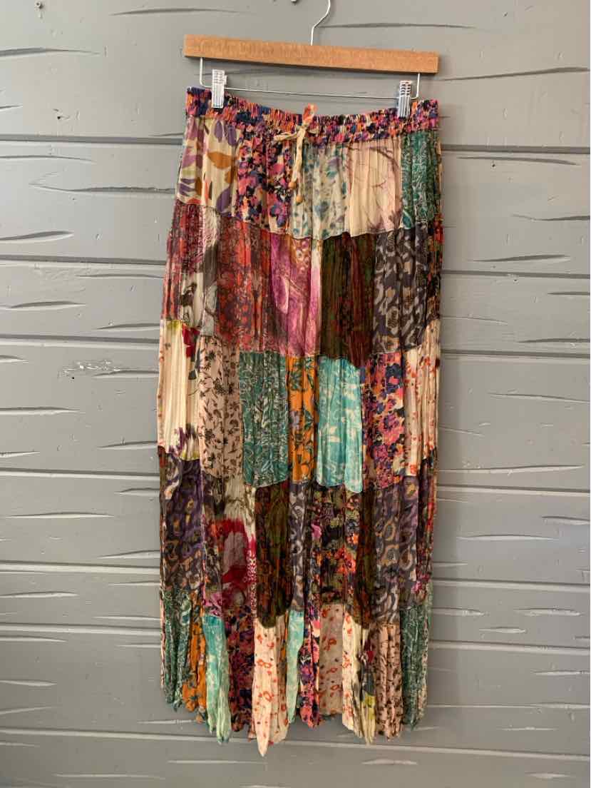 Long patchwork skirt with a mix of floral and geometric prints in earthy tones and bright accents.